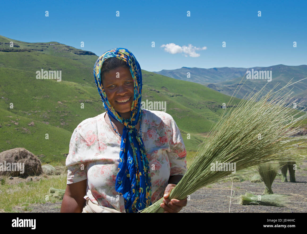 Donna sorridente azienda sole colture secche Maloti Montagne Leribe District Lesotho Africa meridionale Foto Stock
