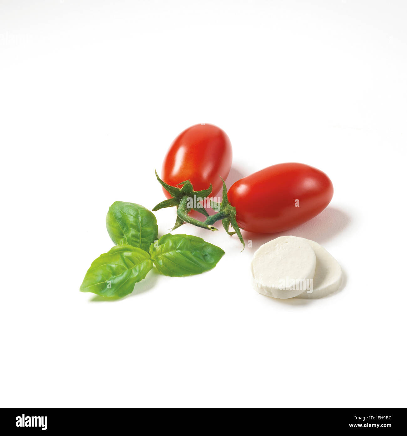 Uva pomodoro, basilico e bocconcini su sfondo bianco Foto Stock