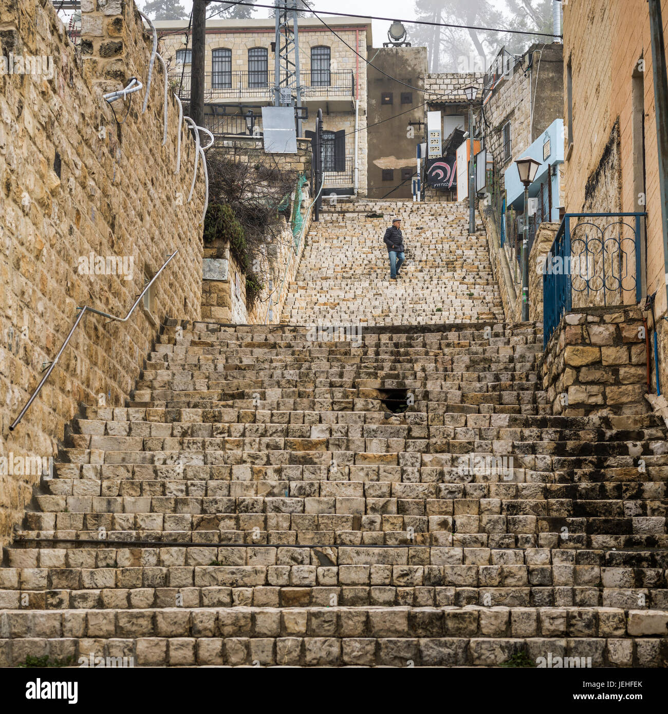Un uomo cammina verso il basso una serie di ripide scale di pietra; Safed, Israele Foto Stock