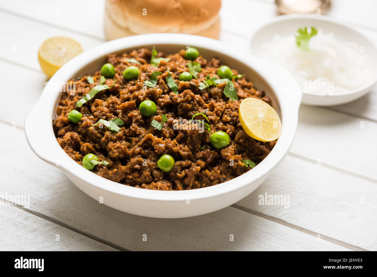 Indian Masala Kheema Pav o khima o secco piccante di carni macinate di solito servito con indiano piatto il pane chiamato kulcha/roti/chapati, guarnita con piselli verdi Foto Stock