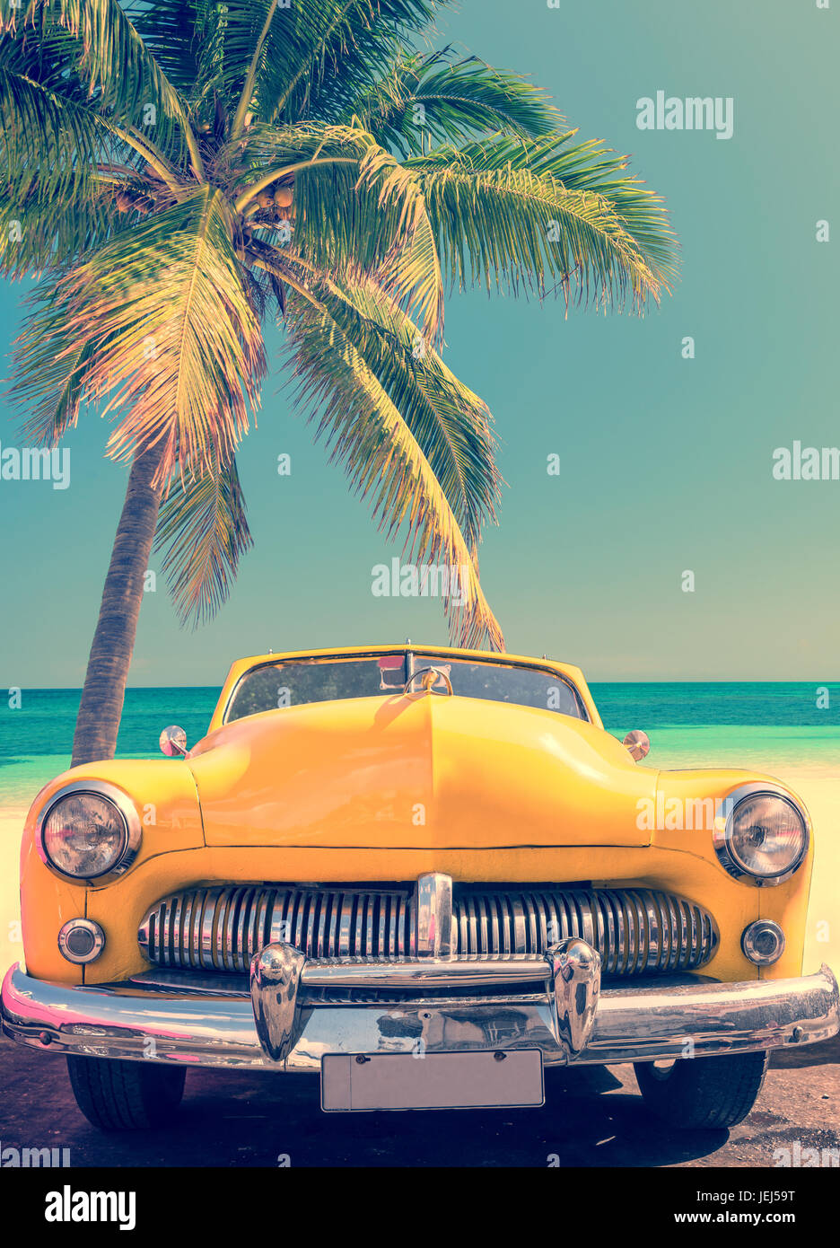 Auto classica su una spiaggia tropicale con palme, processo vintage Foto Stock