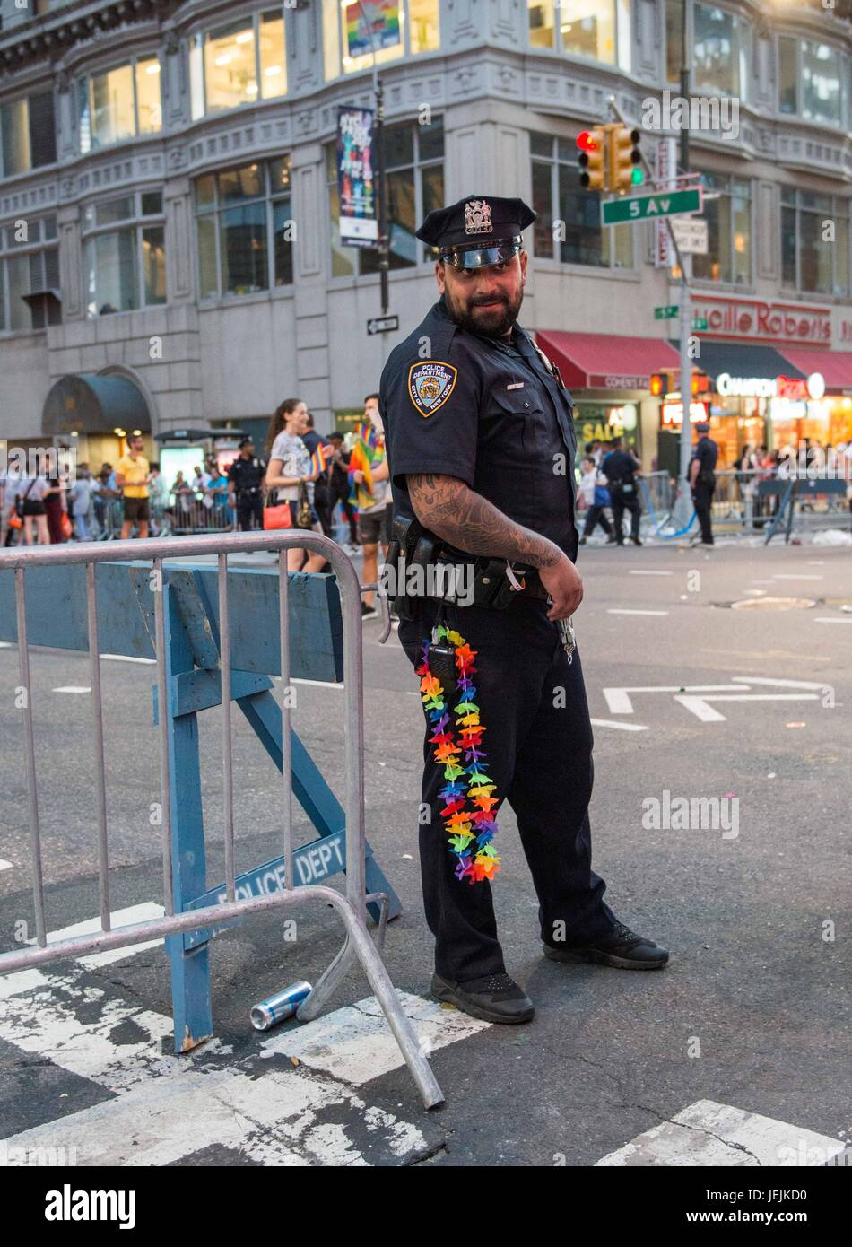New York, Stati Uniti d'America. Il 25 giugno, 2017. Scene dal Giugno 25, 2017 Pride Parade. Un ufficio di polizia il compito di custodire la folla ha un po' di divertimento indossando un arcobaleno di lei e con un commento irriverente posa per una foto. Il primo marzo si è tenuto nel 1970 e da allora è diventata un annuale dei diritti civili di dimostrazione. Nel corso degli anni, il suo scopo ha ampliato per includere il riconoscimento della lotta contro l' AIDS e per ricordare coloro che ci hanno perso per malattia, di violenza e di abbandono. Il mese di marzo è una celebrazione di vita LGBTQ e comunità. Credito: Brigette Supernova/Alamy Live News Foto Stock