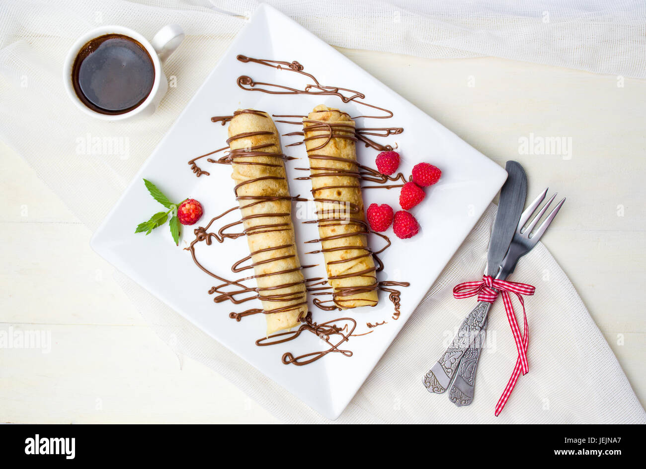 Pancake con fragole e cioccolato su una piastra bianca Foto Stock