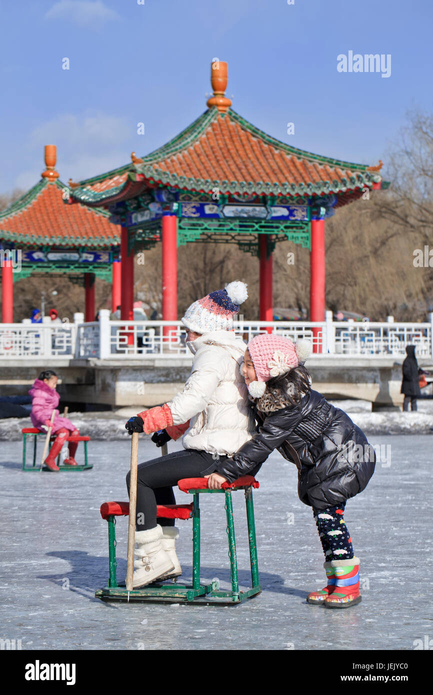 CHANGCHUN – FEB. 4, 2014. Due ragazze si divertono sul ghiaccio nel Nanhu Park Changchun, capitale della provincia di Jilin nord-orientale. Foto Stock