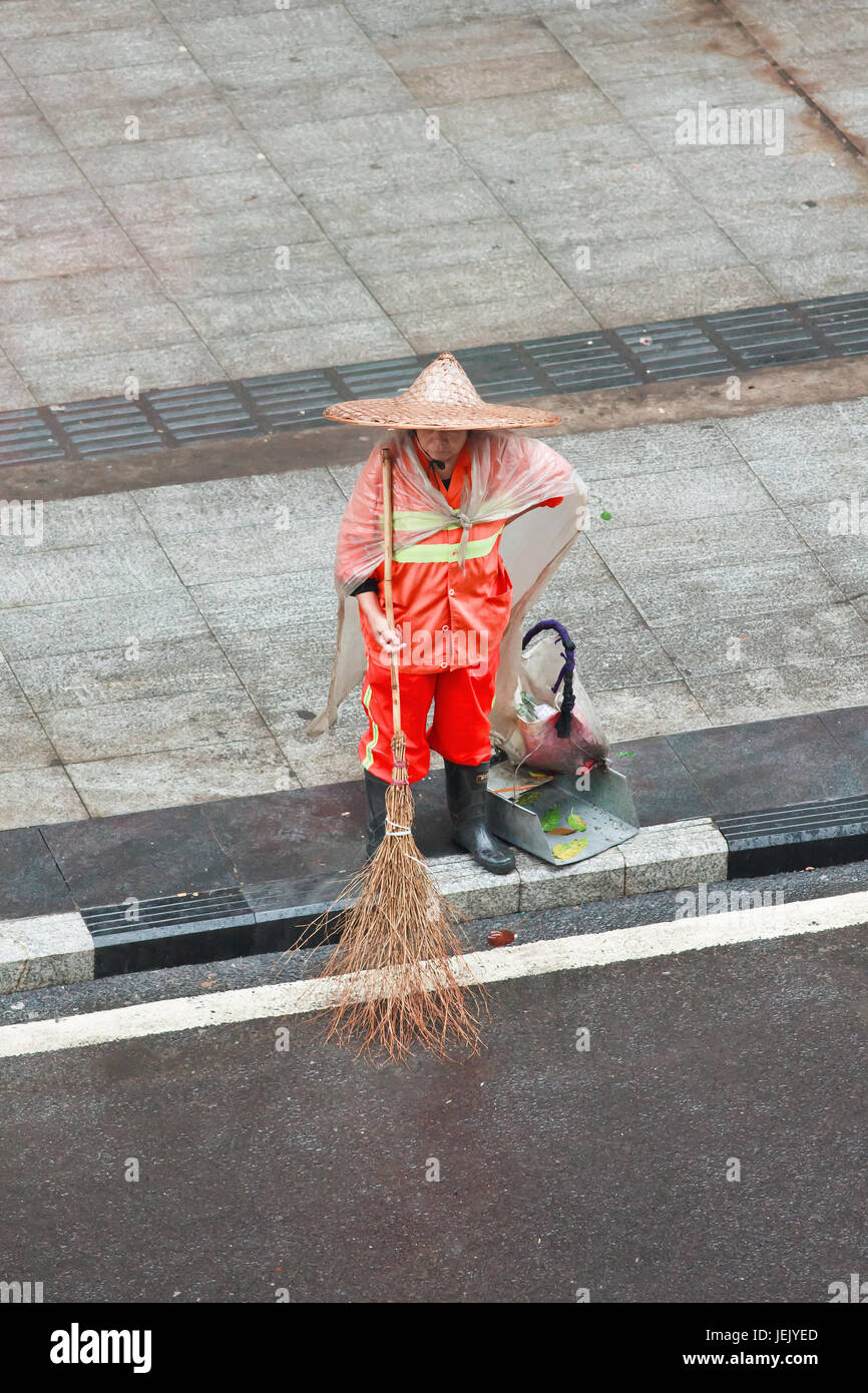 CHONGQING-1° NOVEMBRE 2014. Spazzatrice stradale con scopa. La Cina ha un gigantesco esercito di pulitori di strada vestiti di arancia fanno del loro meglio per pulire giornalmente. Foto Stock