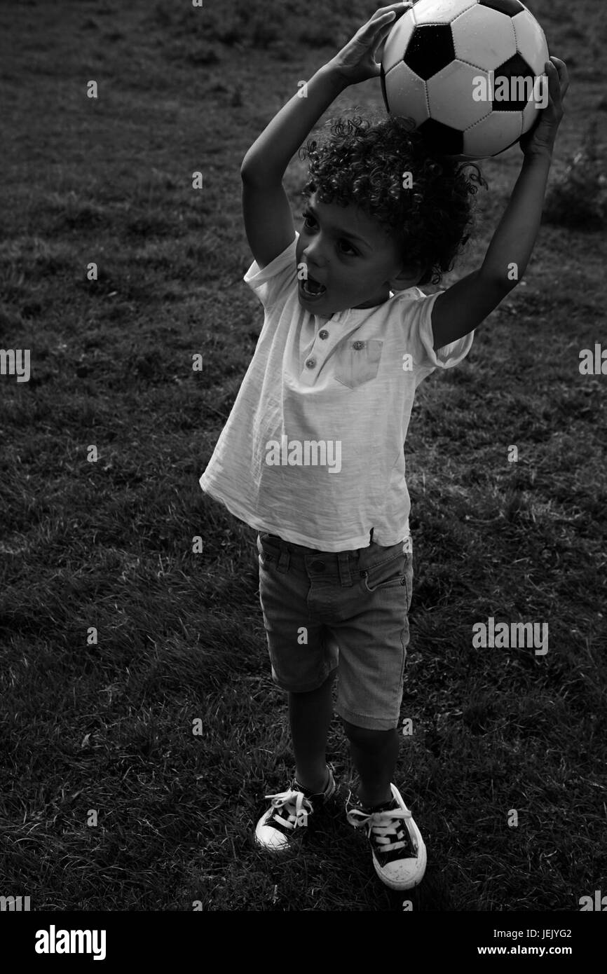 Ragazzo tenendo il calcio Foto Stock