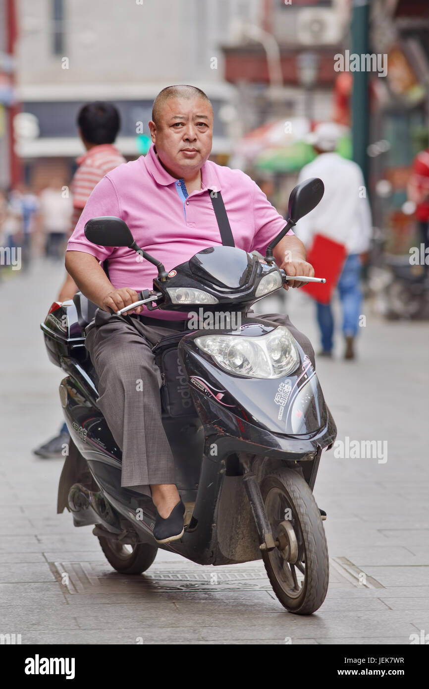 PECHINO-9 GIUGNO 2015. Uomo in sovrappeso su e-bike. Il tasso di obesità cinese è salito alle stelle negli ultimi decenni, con il risultato di 46 milioni di adulti obesi. Foto Stock