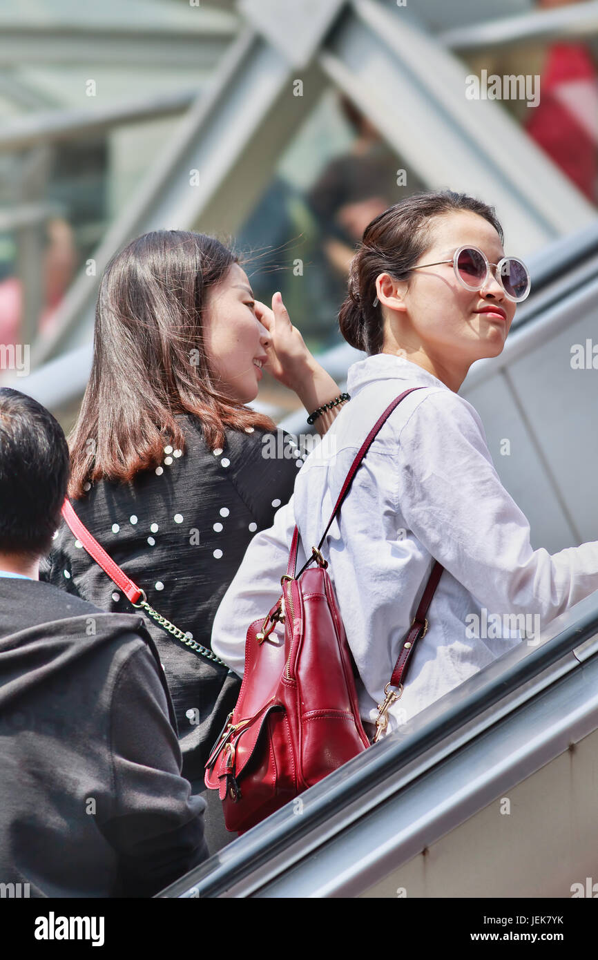 PECHINO-28 APRILE 2016. Ragazze alla moda su una scala mobile. I giovani cinesi vedono la moda come un modo per riflettere aspirazioni e identità. Foto Stock
