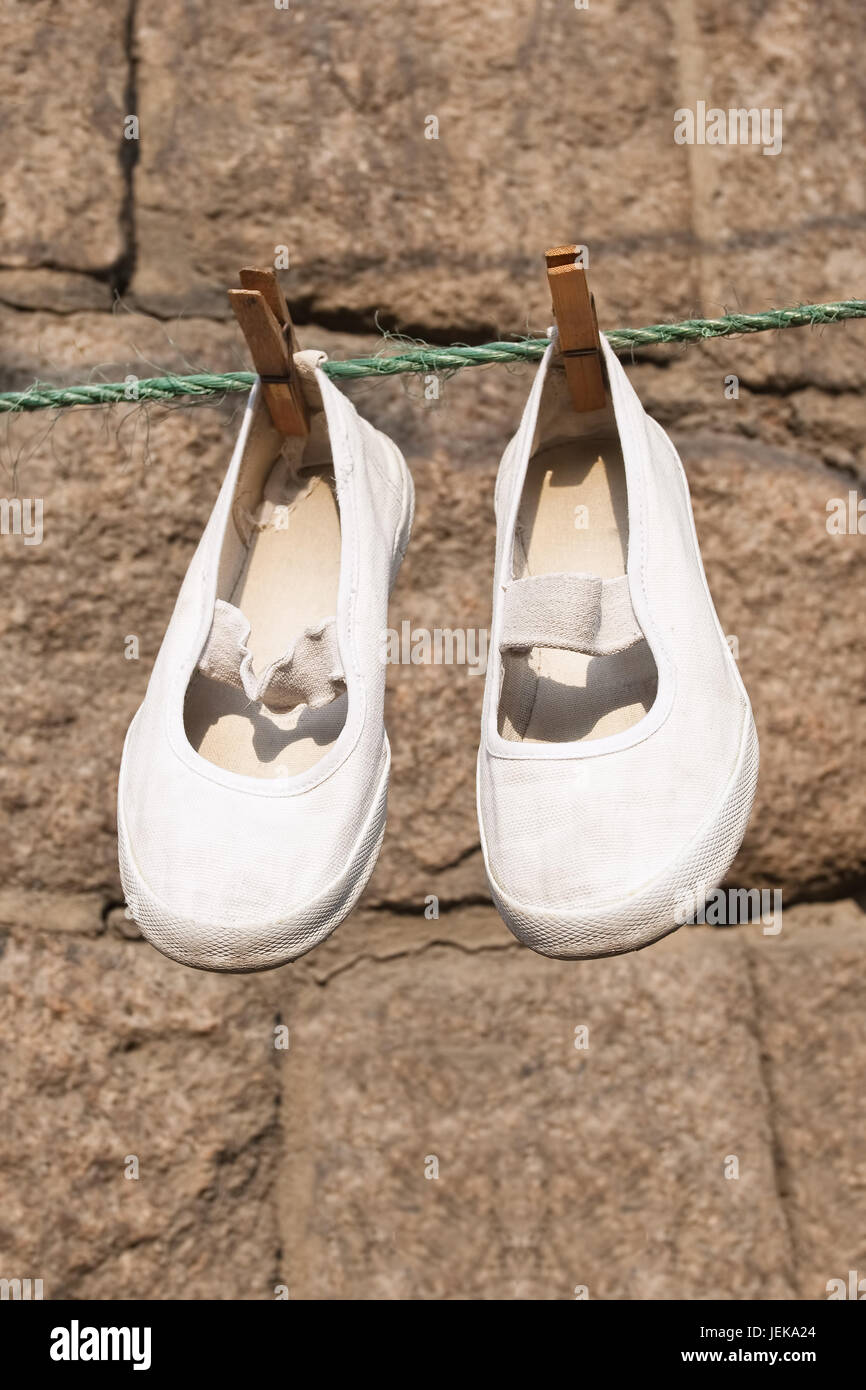 Scarpe cinesi appendere su una linea di lavanderia a secco Foto Stock