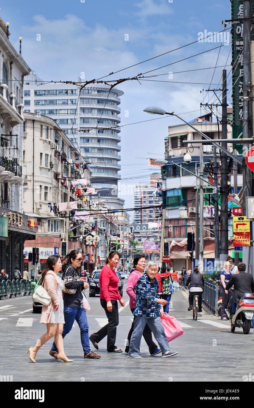 SHANGHAI-5 MAGGIO 2014. Donne che attraversano la strada in zona densa. Le densità urbane hanno una media di circa 40.000 residenti per CHILOMETRO quadrato nei distretti centrali. Foto Stock