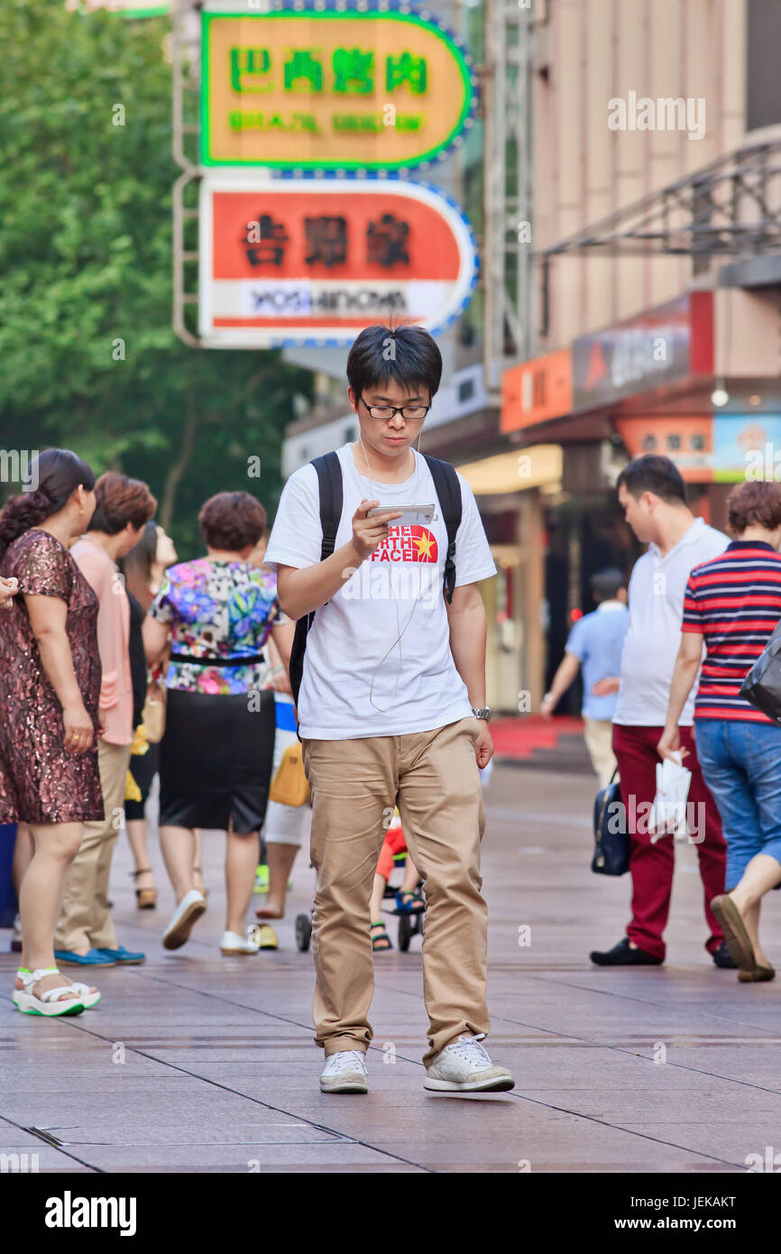 Giovane uomo con lo smartphone. La Cina ha più utenti dello smartphone rispetto a Stati Uniti, Brasile e Indonesia combinati. Foto Stock