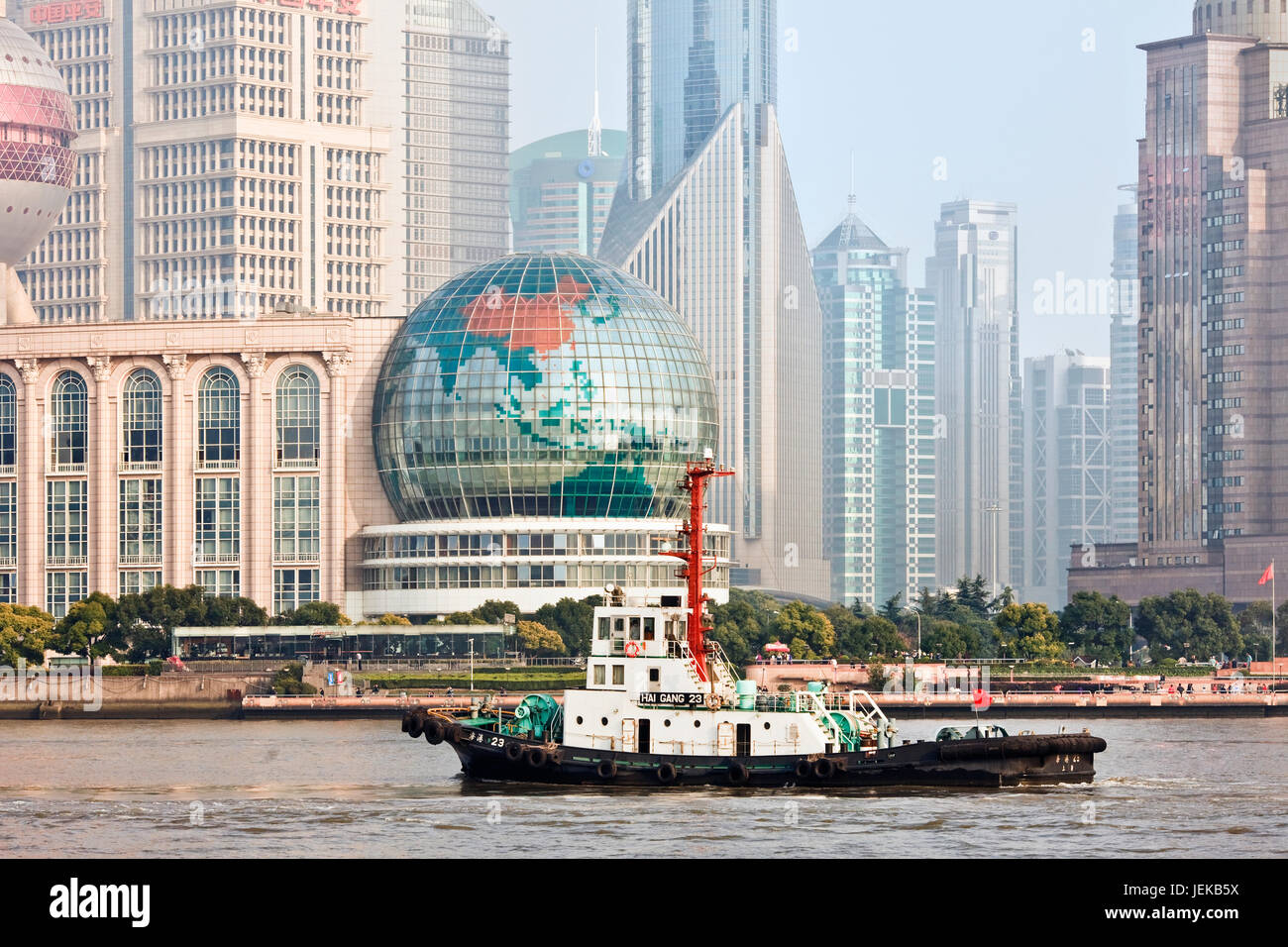 Rimorchiatore a traino con il Distretto di Pudong sullo sfondo di Shanghai. Case di Pudong Lujiazui Finance and Trade Zone, Stock Exchange e è la Cina del centro finanziario. Foto Stock