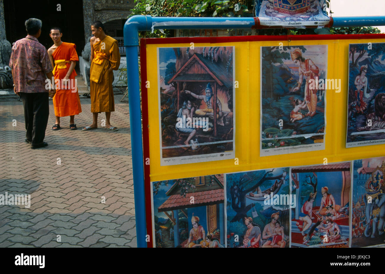 Thailandia, a Nord di Chiang Mai, Wat Bupparam tempio sulla Tha Phae Road. Visualizzazione delle copertine nel cortile dominato da due monaci e visitatore. Mostra buddisti indù link. Foto Stock
