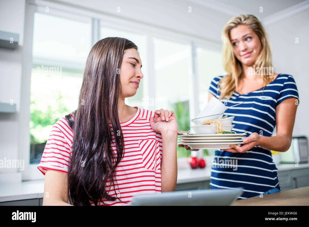 Turbare la donna che mostra i piatti sporchi ad un amico Foto Stock