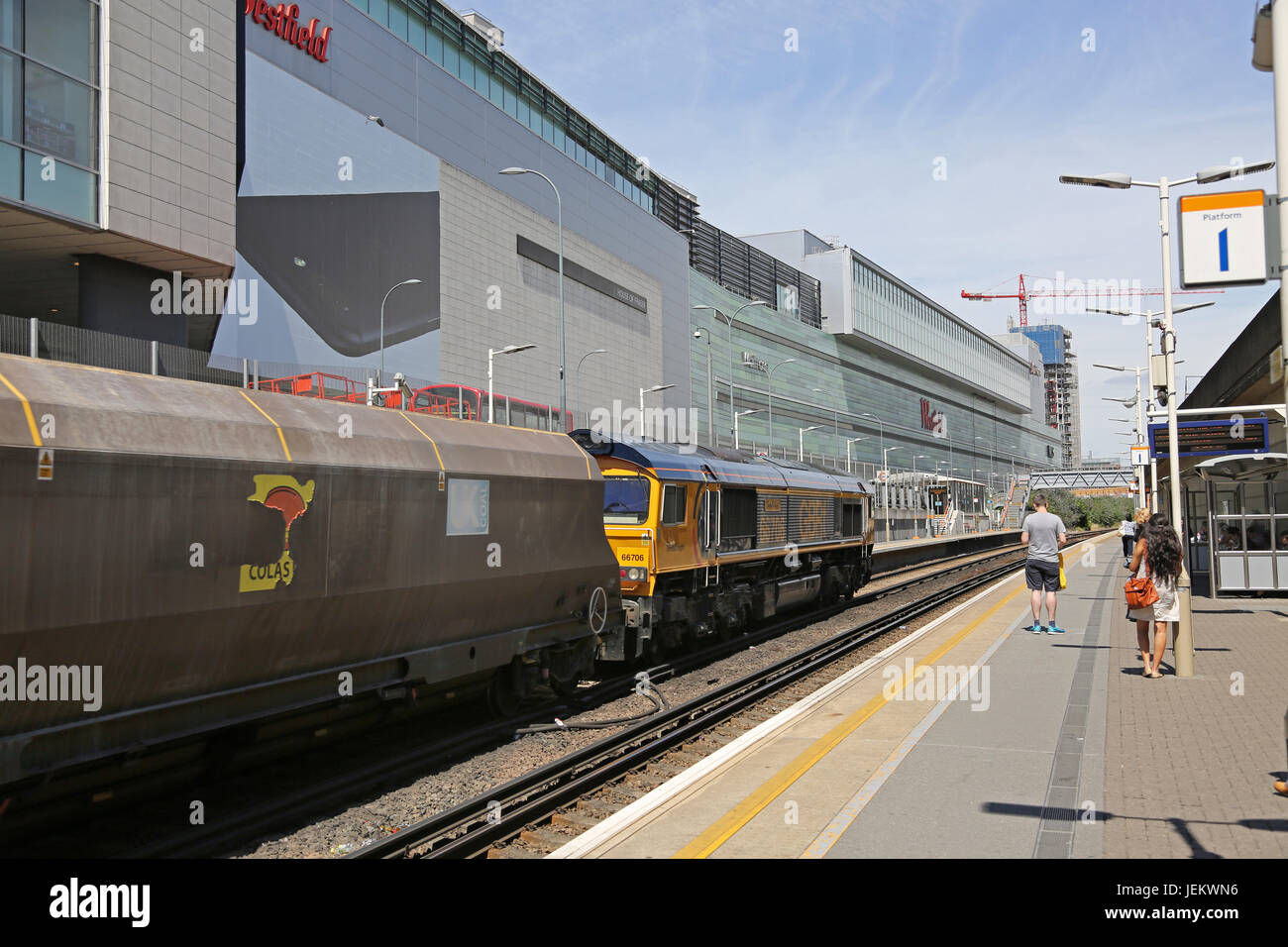 Un treno di merci passa attraverso la recente costruzione Shepherds Bush stazione, accanto al centro commerciale Westfield nella zona ovest di Londra Foto Stock