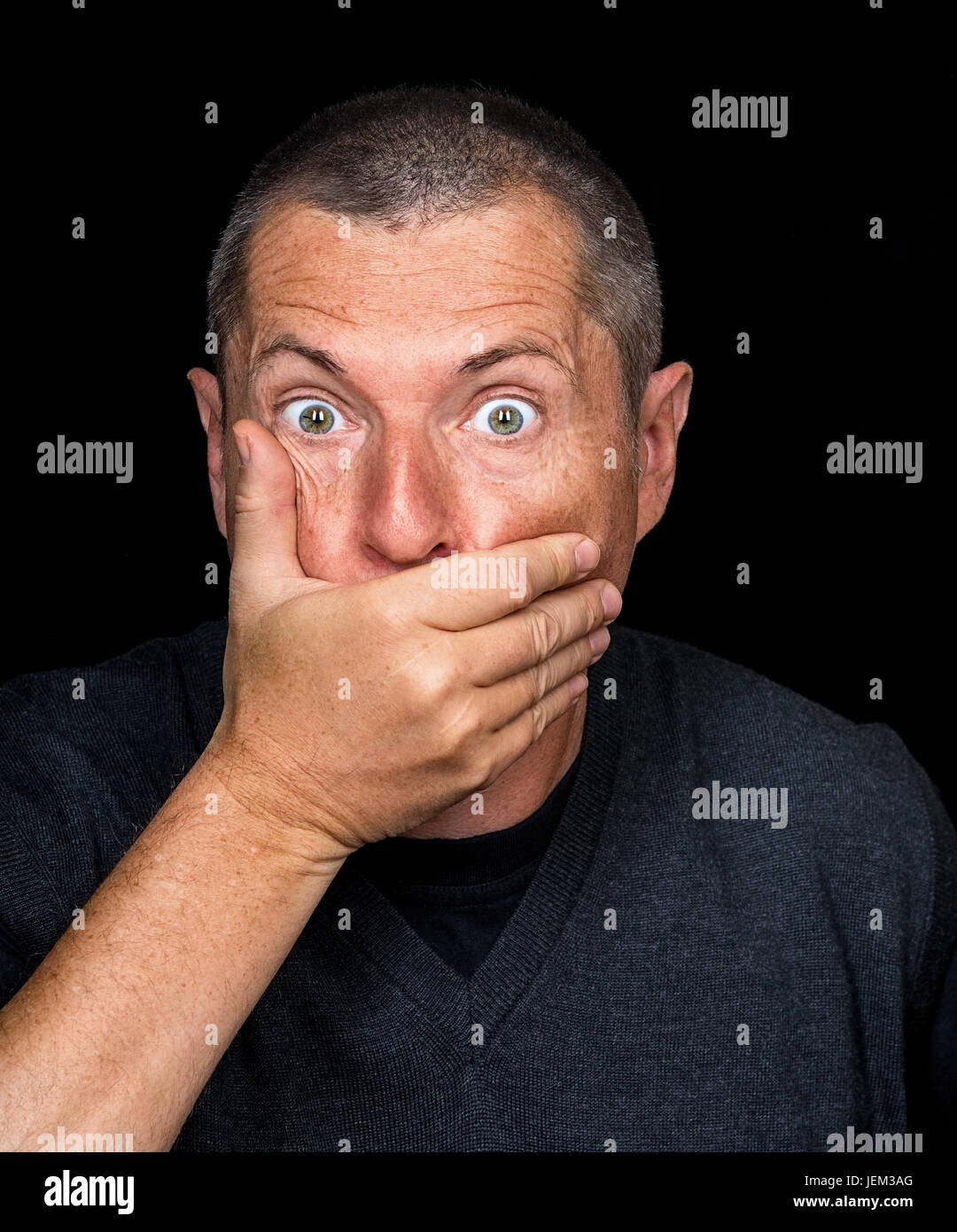 Ritratto di un uomo con emozioni grottesche su sfondo nero Foto Stock
