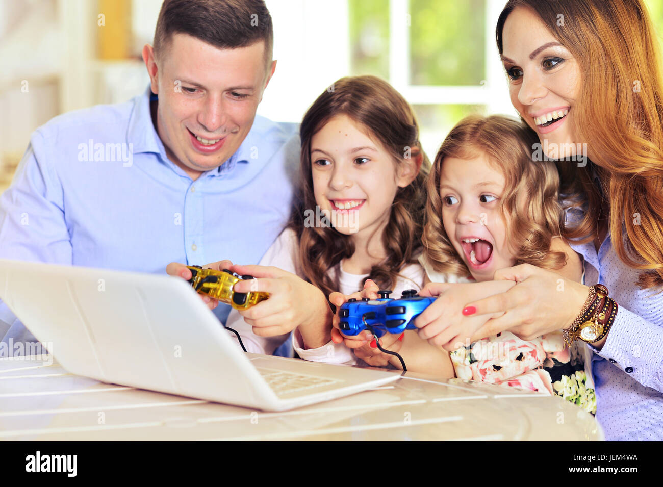 Famiglia giocando su laptop a tavola Foto Stock