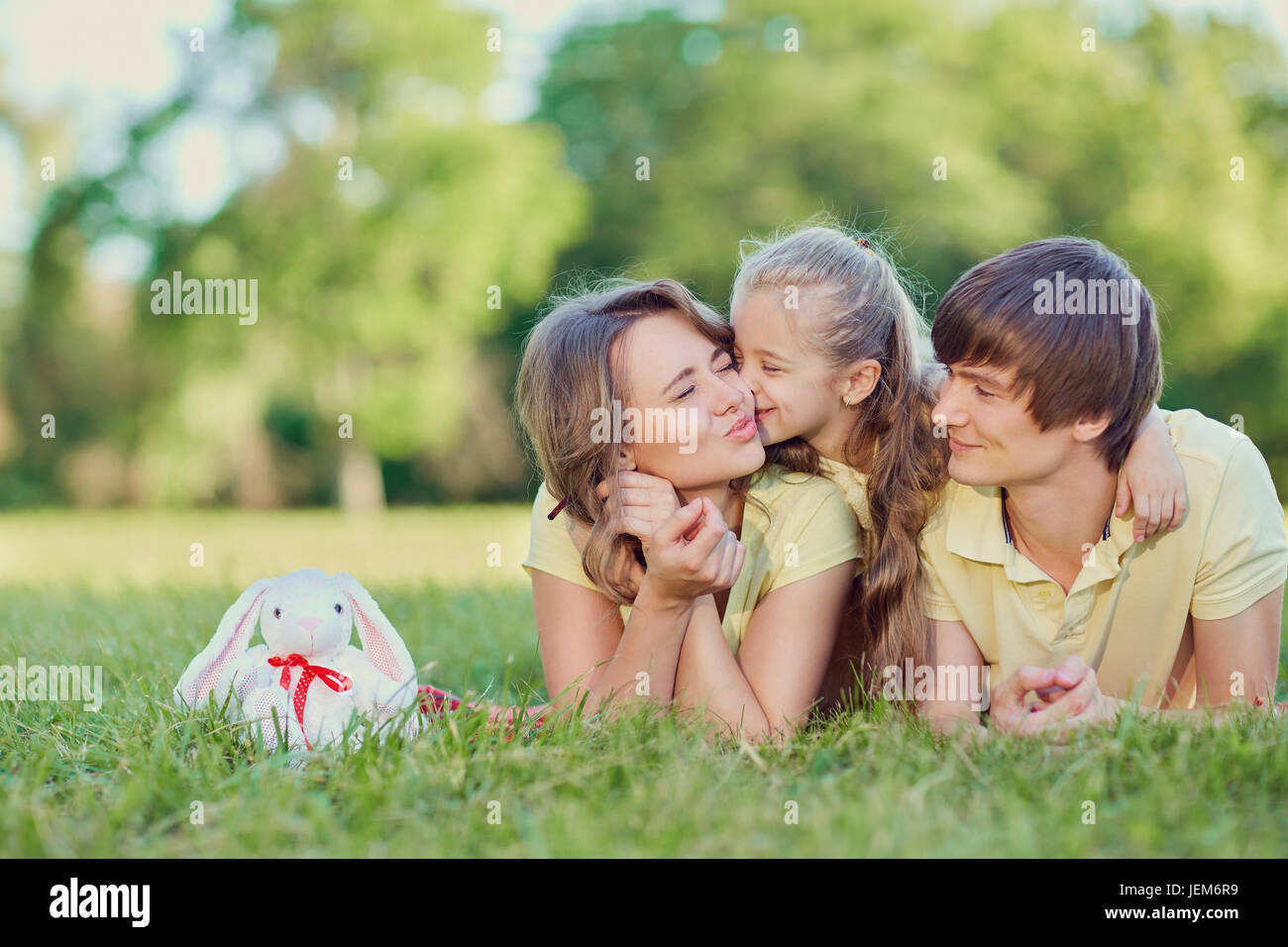 La famiglia felice giacente su erba nel parco. Foto Stock