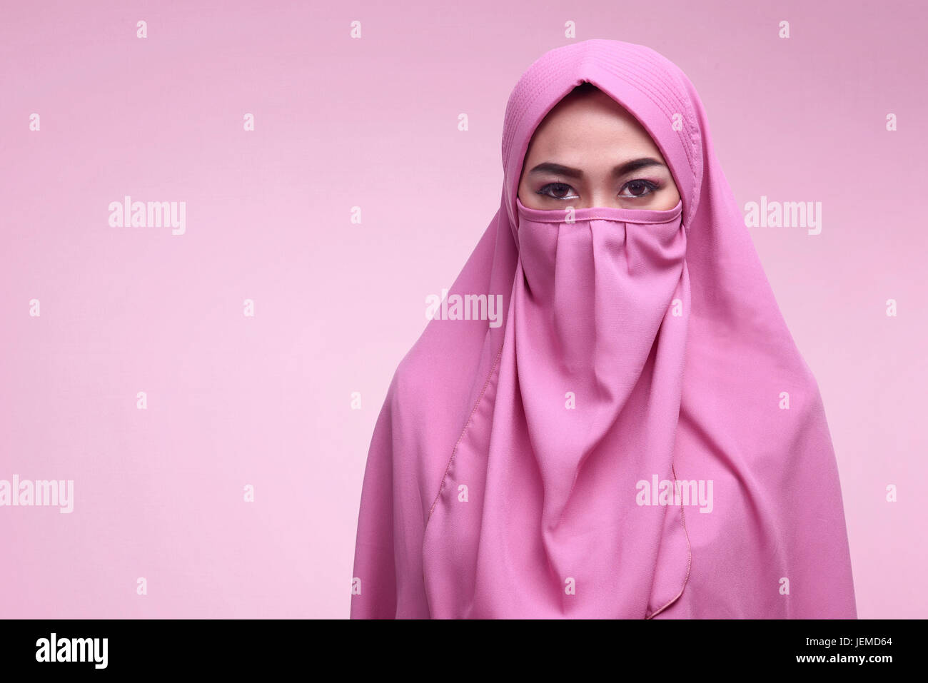 Giovani asiatici donna musulmana di indossare niqab su sfondo rosa Foto  stock - Alamy