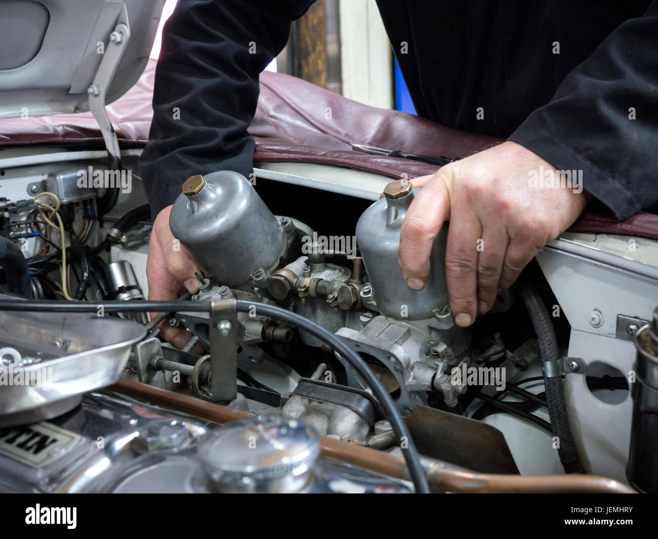 Classic car meccanica lavorando su una vettura nel loro seminario Foto Stock