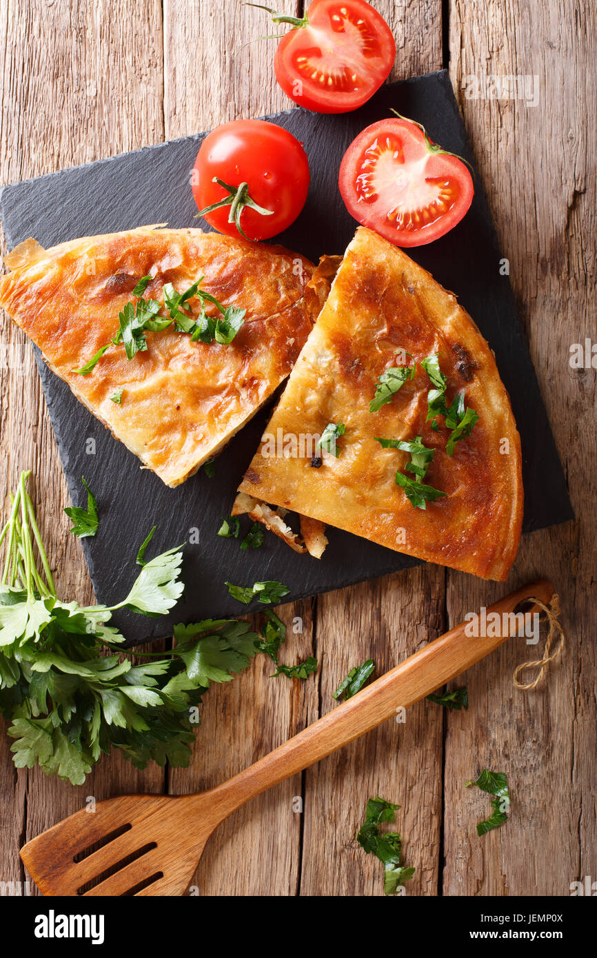 Il cibo dei Balcani: burek con carne di close-up sul tavolo. vista verticale da sopra Foto Stock