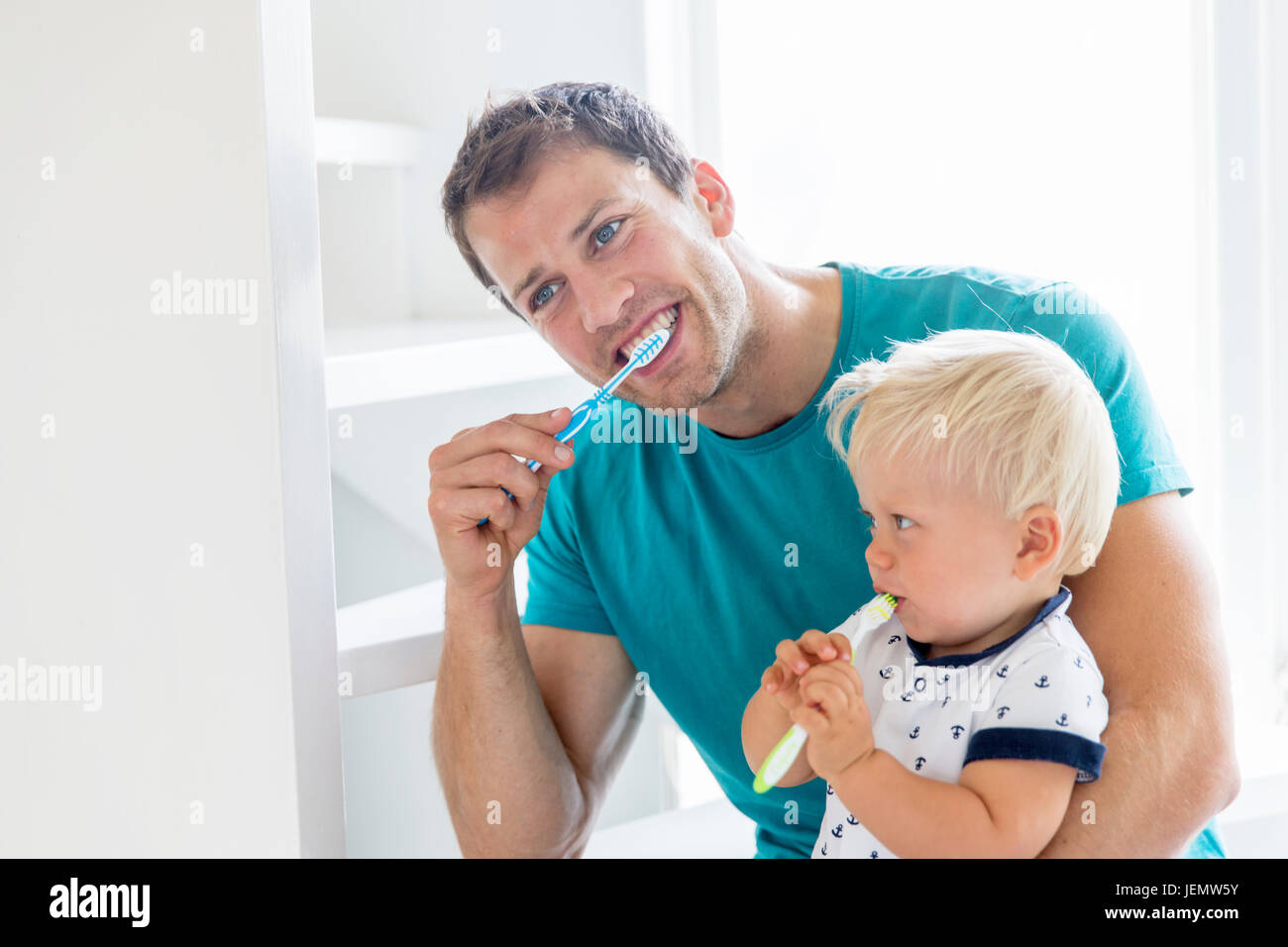 Padre e figlio di spazzolare i denti insieme Foto Stock