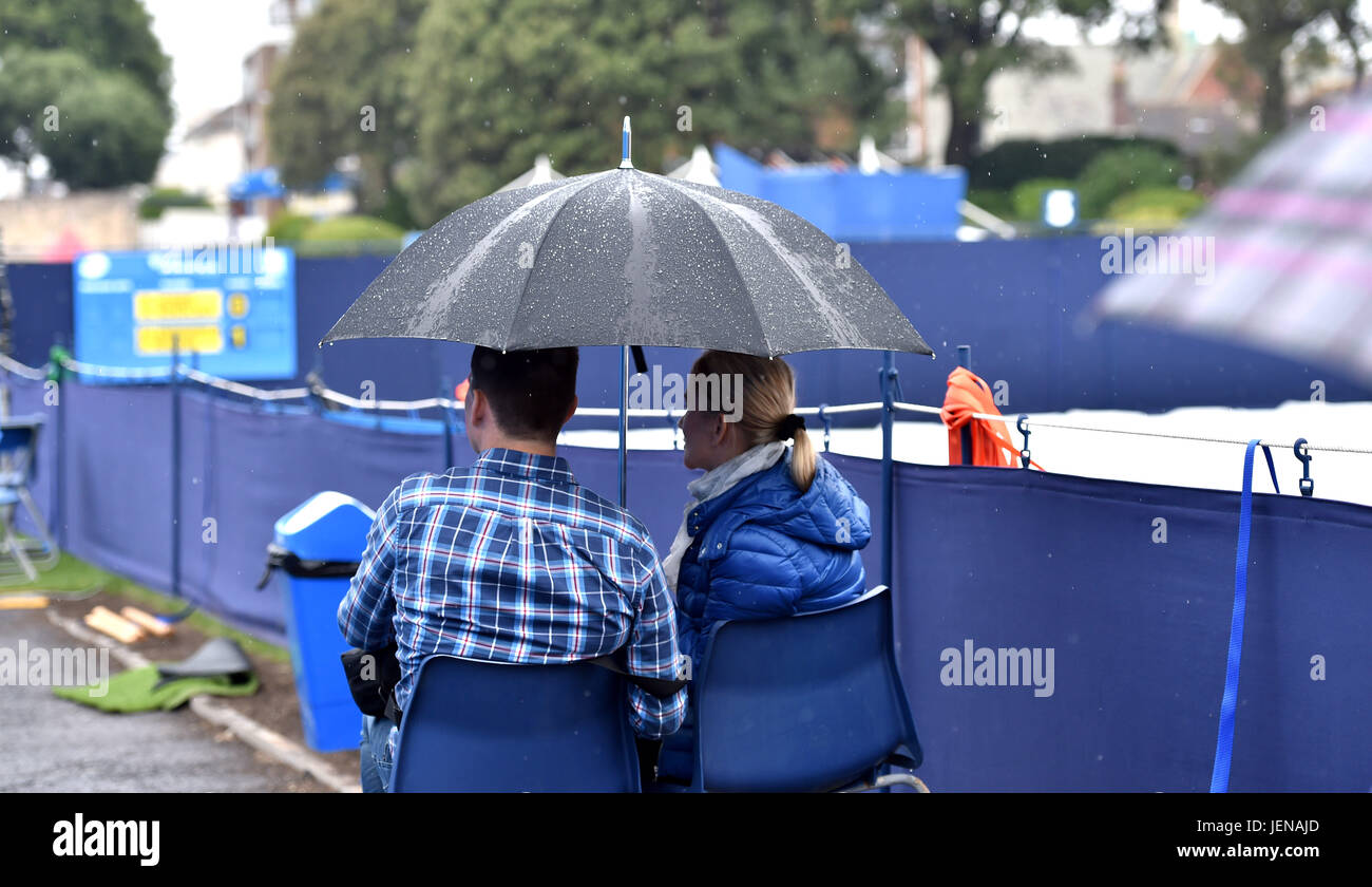 Eastbourne Sussex, Regno Unito. Il 27 giugno, 2017. Spettatori riparo sotto gli ombrelli da pioggia smette di giocare al Aegon International Eastbourne Tennis Tournament come una miscela di docce e temporali si è diffusa in tutto il sud est della Gran Bretagna oggi Credito: Simon Dack/Alamy Live News Foto Stock