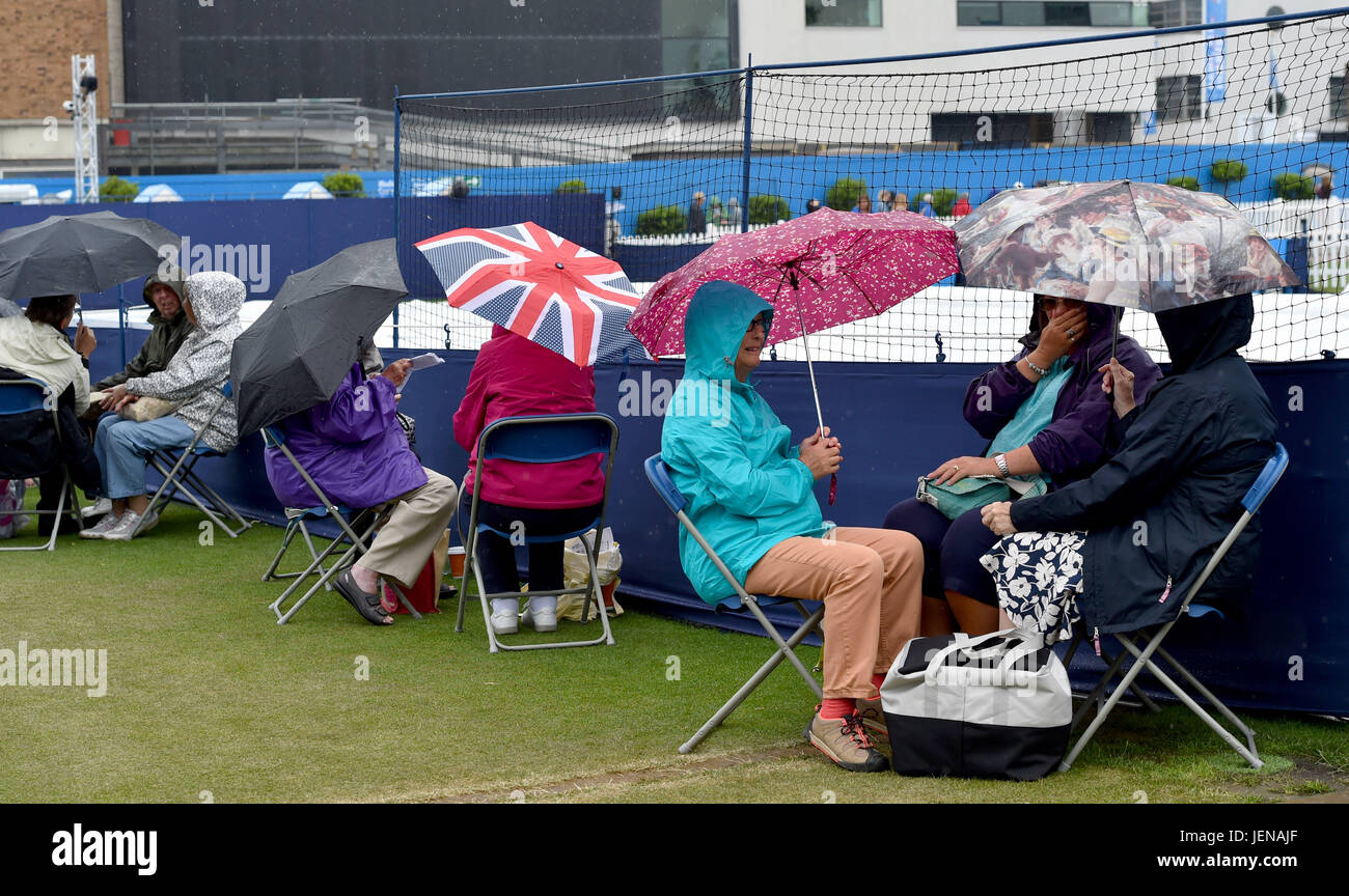 Eastbourne Sussex, Regno Unito. Il 27 giugno, 2017. Spettatori riparo sotto gli ombrelli da pioggia smette di giocare al Aegon International Eastbourne Tennis Tournament come una miscela di docce e temporali si è diffusa in tutto il sud est della Gran Bretagna oggi Credito: Simon Dack/Alamy Live News Foto Stock