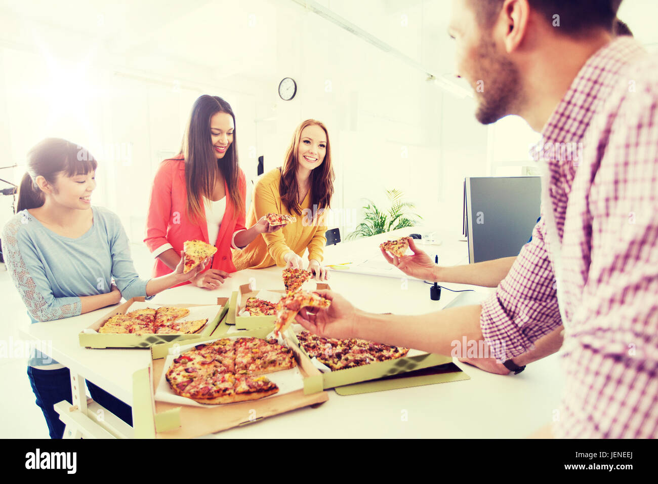 Happy business team di mangiare la pizza in ufficio Foto Stock