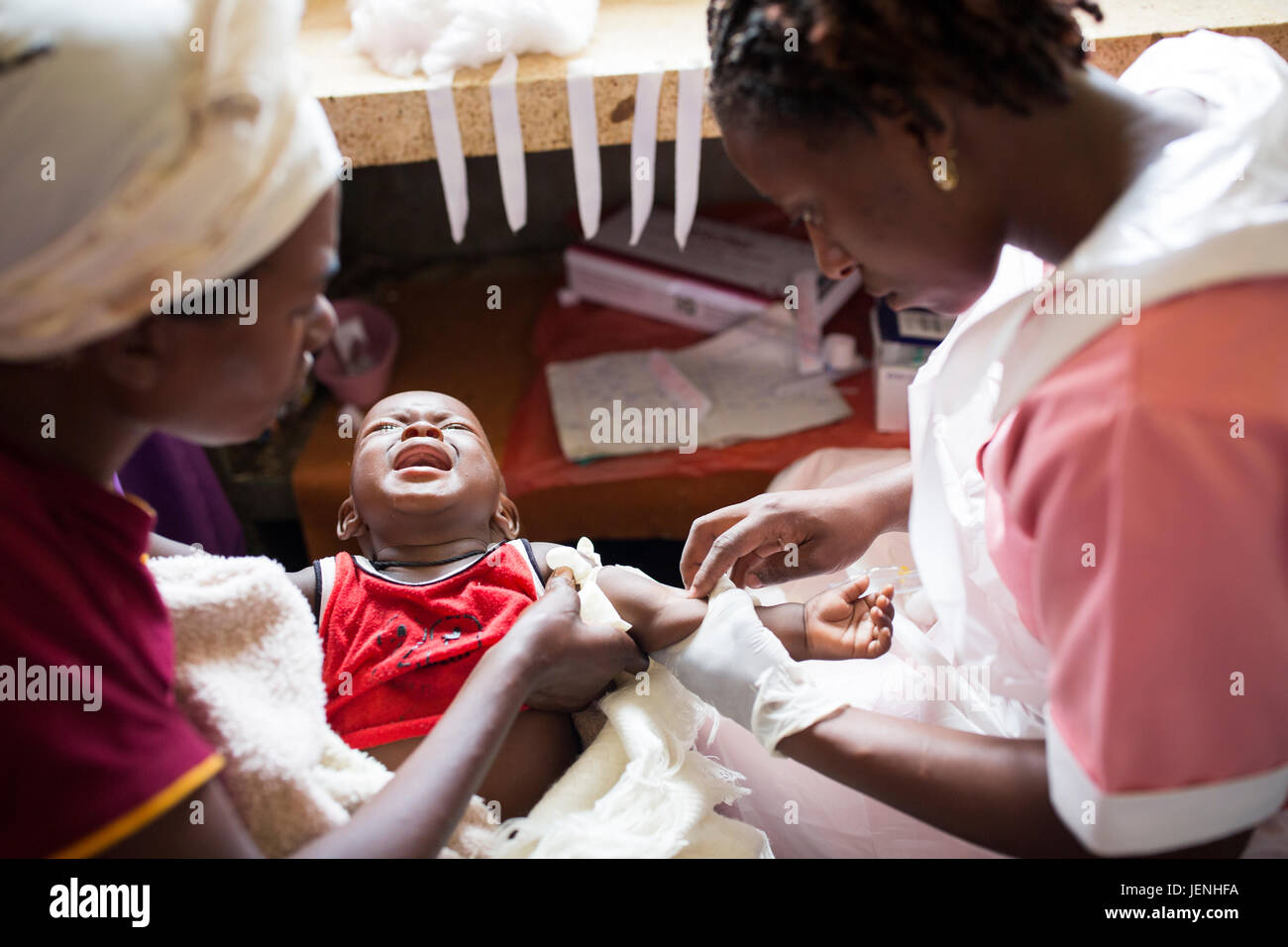 Un infermiere somministra il farmaco al bambino per via endovenosa in un ospedale di Bundibugyo, Uganda. Foto Stock