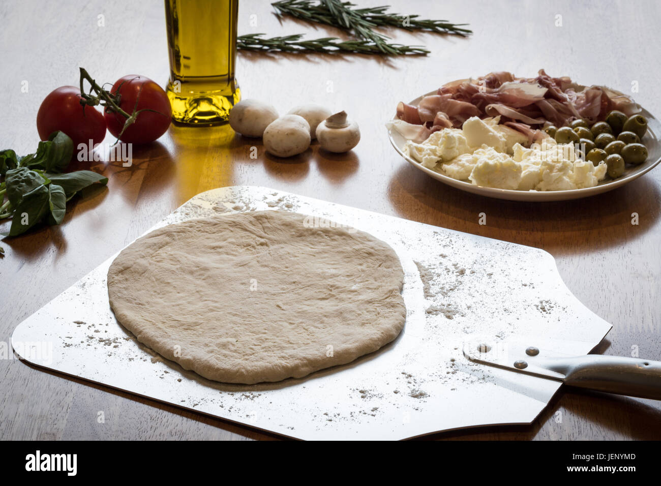 Una base per pizza su un Peel pronto per topping Foto Stock