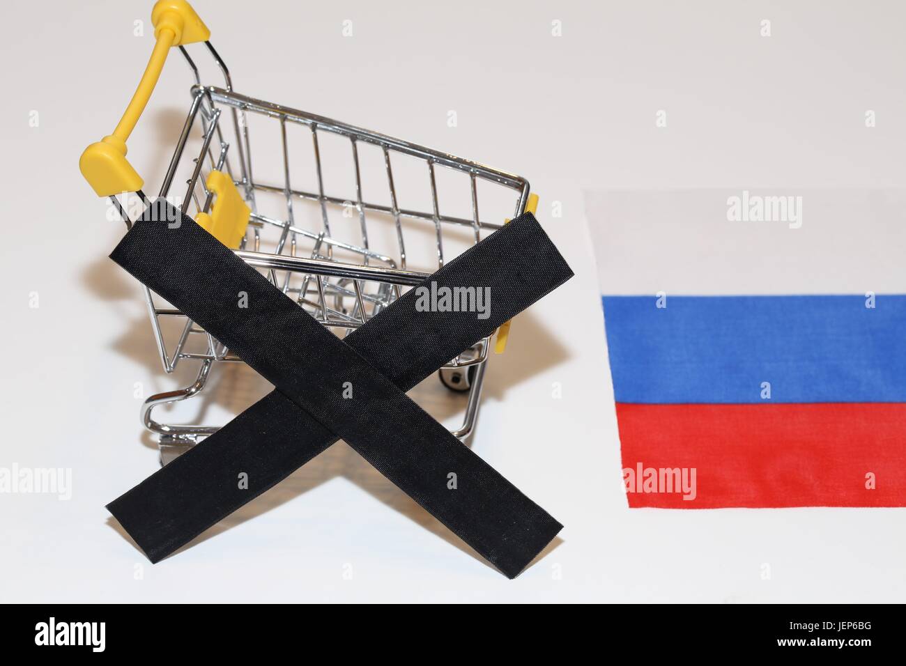 Carrello spesa e nero nella parte anteriore di una bandiera russa simbolize stop di importazione di prodotti alimentari in Russia Foto Stock
