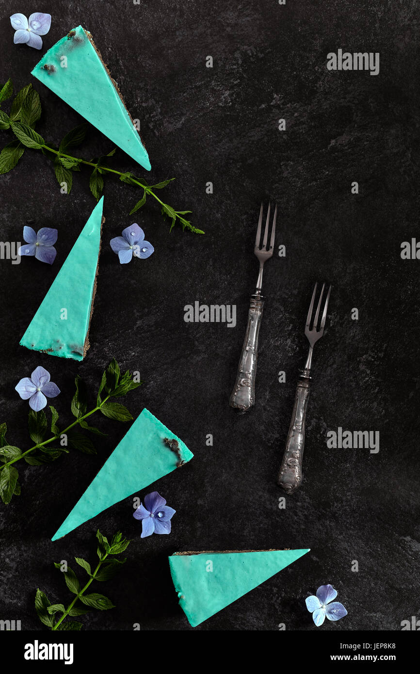 Fette di torta con la menta, formaggio e cioccolato fondente. Lay piatto con copia spazio. Foto Stock