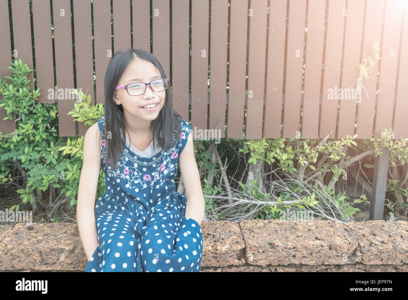 Ritratto di bella ragazza asiatica in giardino. Concetto bambina attraente. Foto Stock