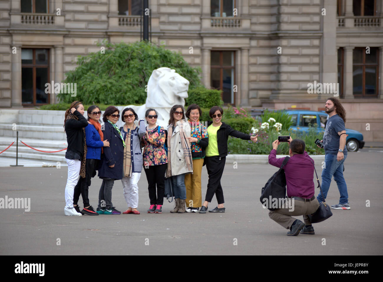 Turisti asiatici in George Square Glasgow Scozia tenendo selfies e fotografie principalmente cinesi e giapponesi Foto Stock