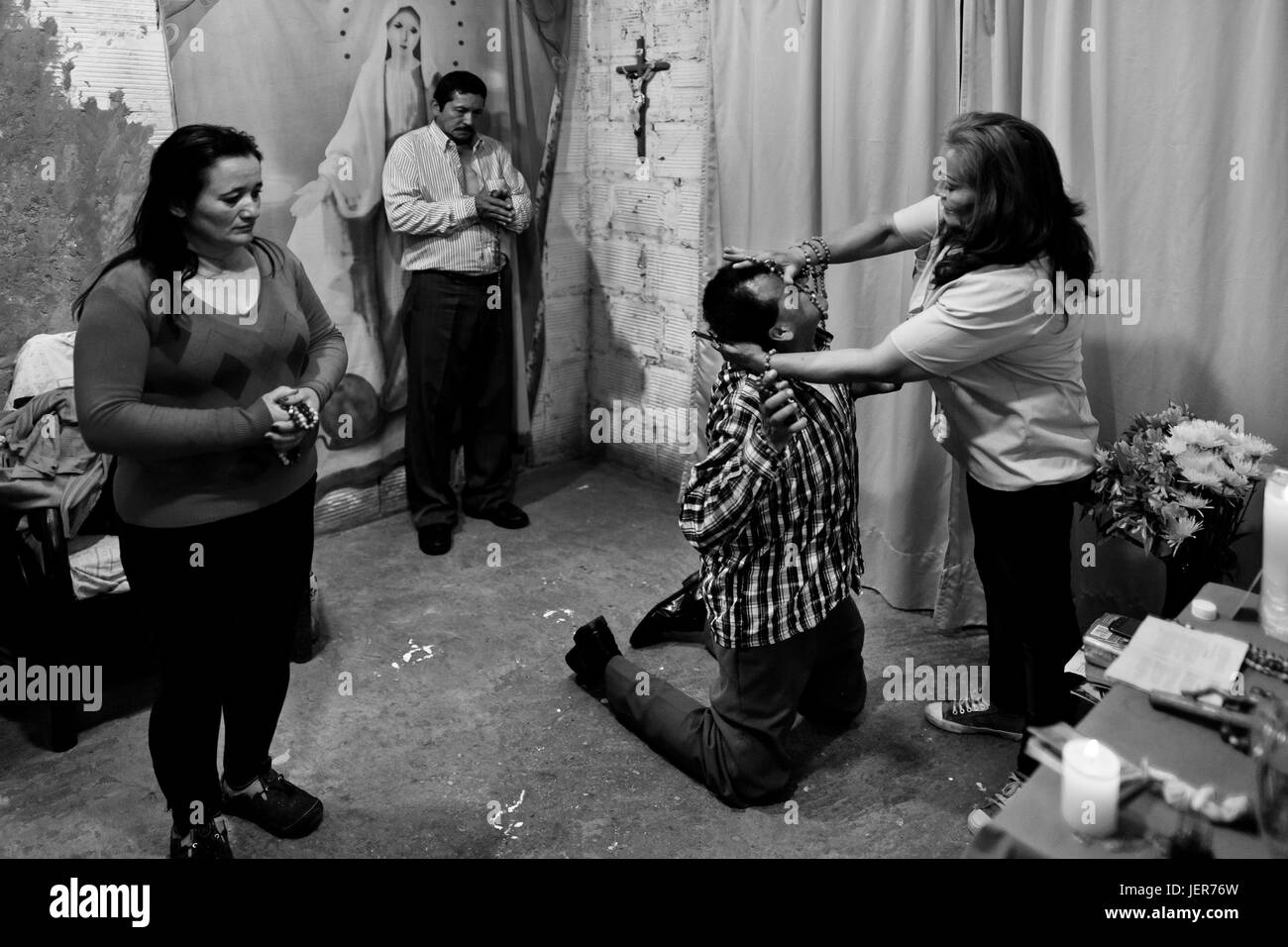 Un colombiano pastore, premendo su un credente la testa, tenta di sfrattare un presunto demone durante il rituale di esorcismo eseguito ad una Chiesa casa a Bogotà, Colombia, 10 marzo 2016. Centinaia di cristiani belivers, riunite in gruppi anonimi, si riuniscono ogni settimana di utilizzo | in tutto il mondo Foto Stock