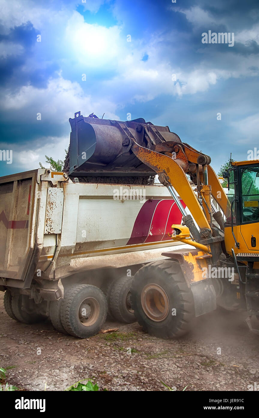 Carichi di escavatore ghiaia nel carrello Foto Stock