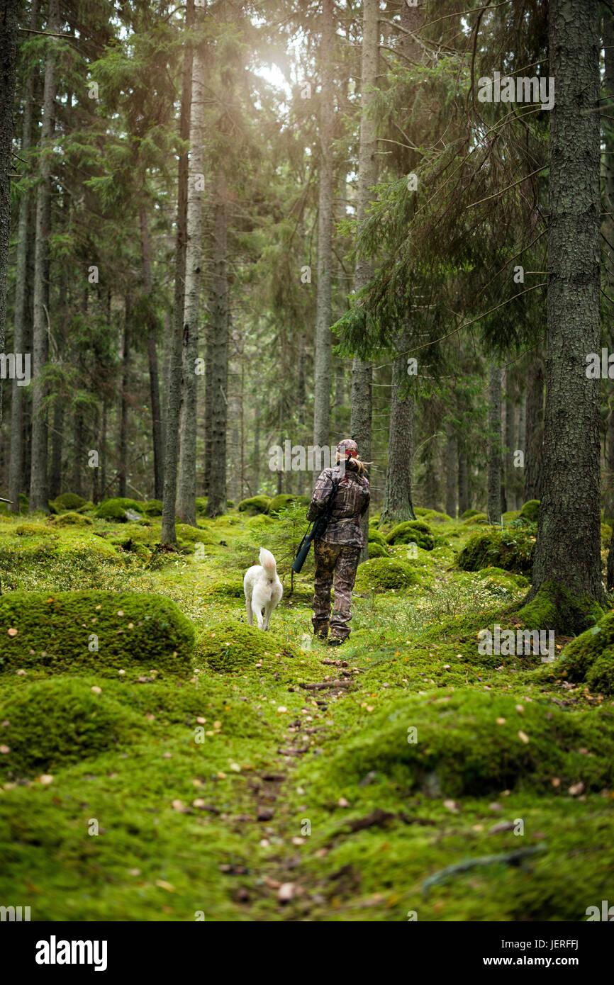 Donna con cane da caccia nella foresta Foto Stock