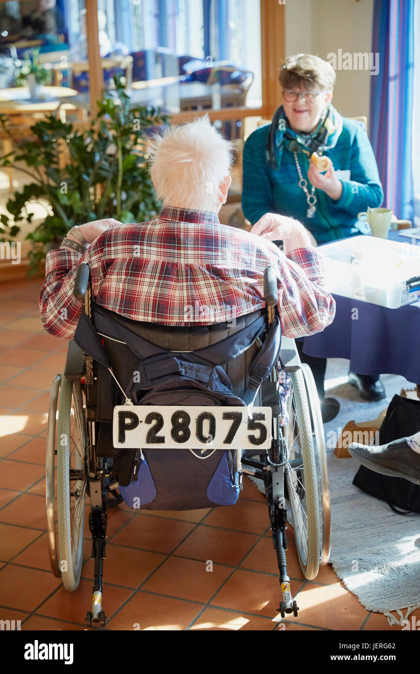 Senior uomo che parla con infermiere in casa di cura Foto Stock