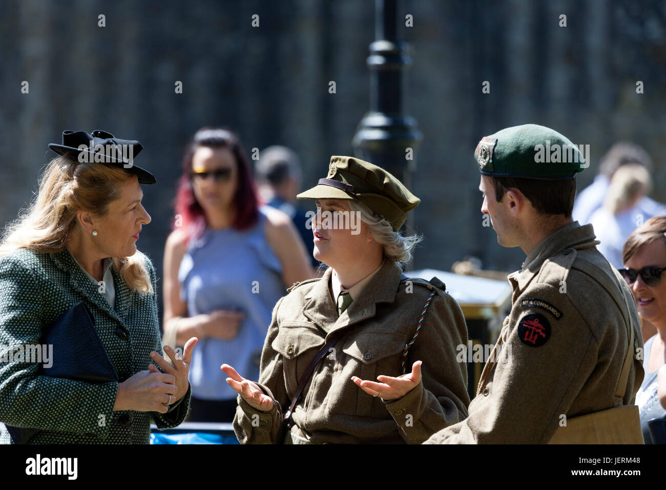 Tre persone in chat mentre indossa degli anni quaranta capi di abbigliamento di stile e uniformi militari durante il 2017 Barnard Castle 1940's Weekend, County Durham, Regno Unito. Foto Stock