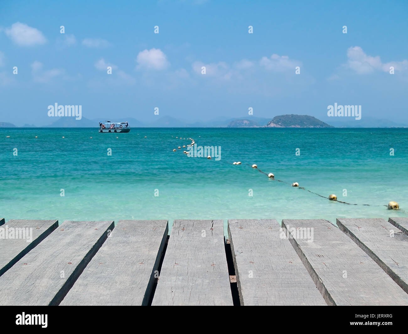 Il lungomare con il mare smeraldo e barca Foto Stock