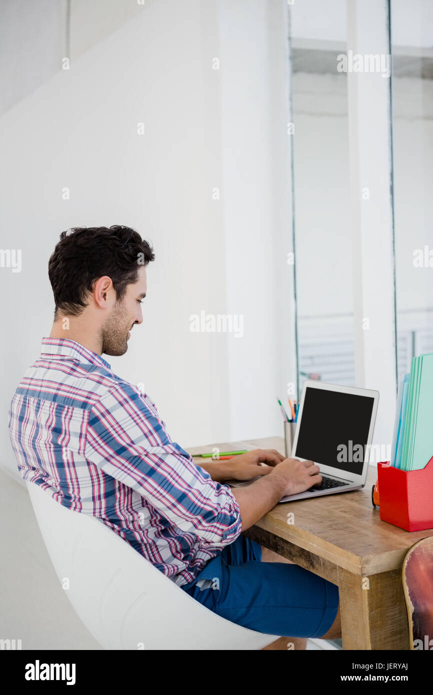 Giovane uomo che lavora alla sua scrivania Foto Stock