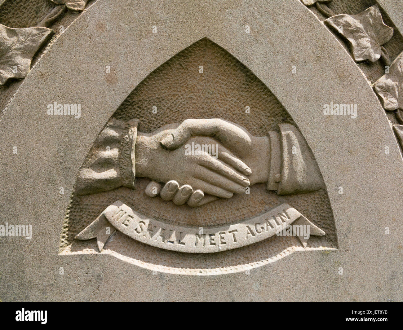 Una scultura in pietra su una lapide che mostra due mani agitando con un 'Ci incontreremo di nuovo testo" Foto Stock