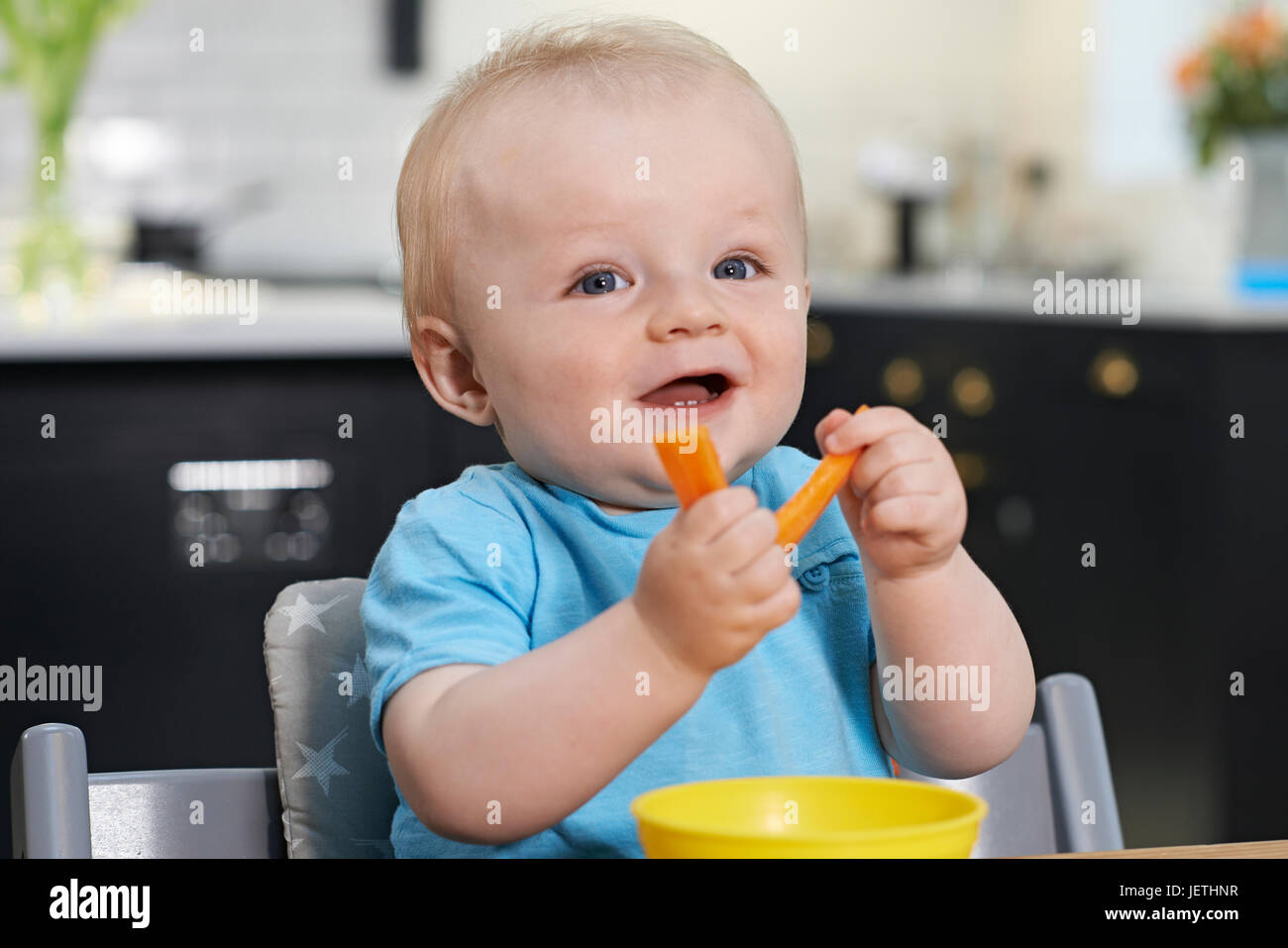 Bimbi felici seduta a tavola a mangiare le carote fresche Foto Stock