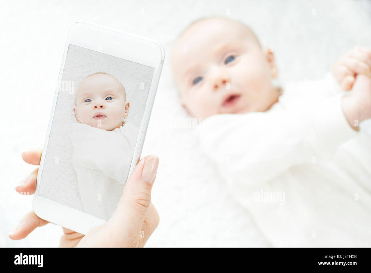 Madre di scattare una foto di Bambina sul telefono cellulare Foto Stock