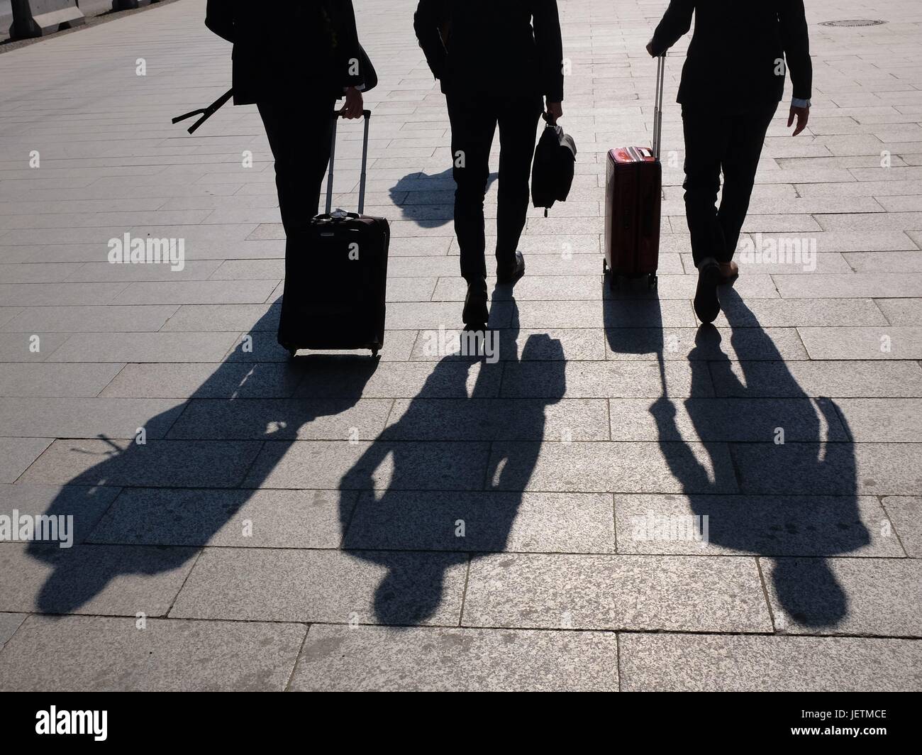 Die Schatten dreier Geschäftsleute, die mit ihren Rollkoffern zu einem Termin eilen. Foto: M. C. Hurek | Utilizzo di tutto il mondo Foto Stock