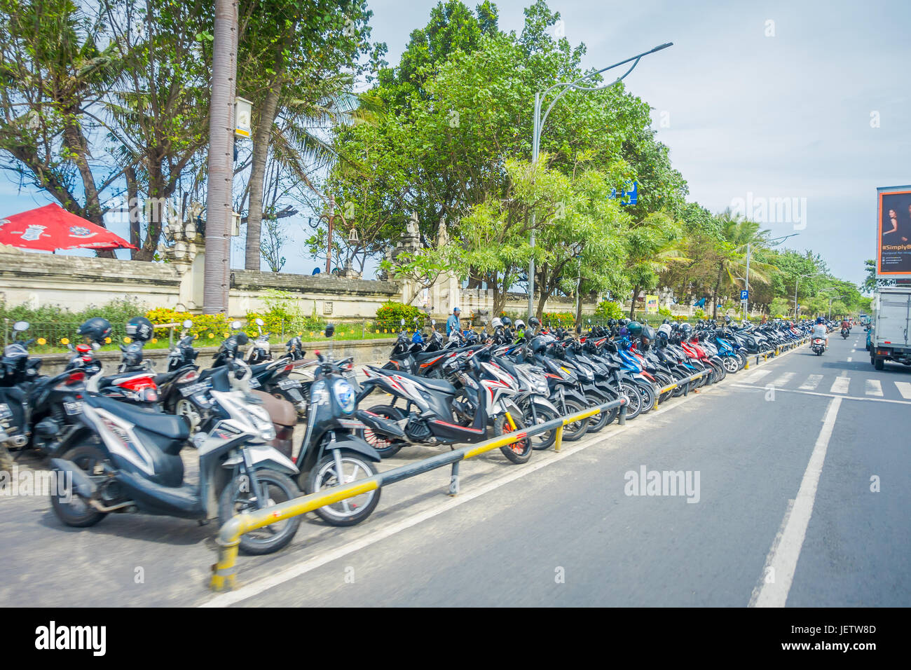 BALI - INDONESIA marzo 08. 2017: un uomo non identificato avendo cura di motociclista parcheggiata in centro. Legian area del. Legian è un suburbana e area di spiaggia Foto Stock