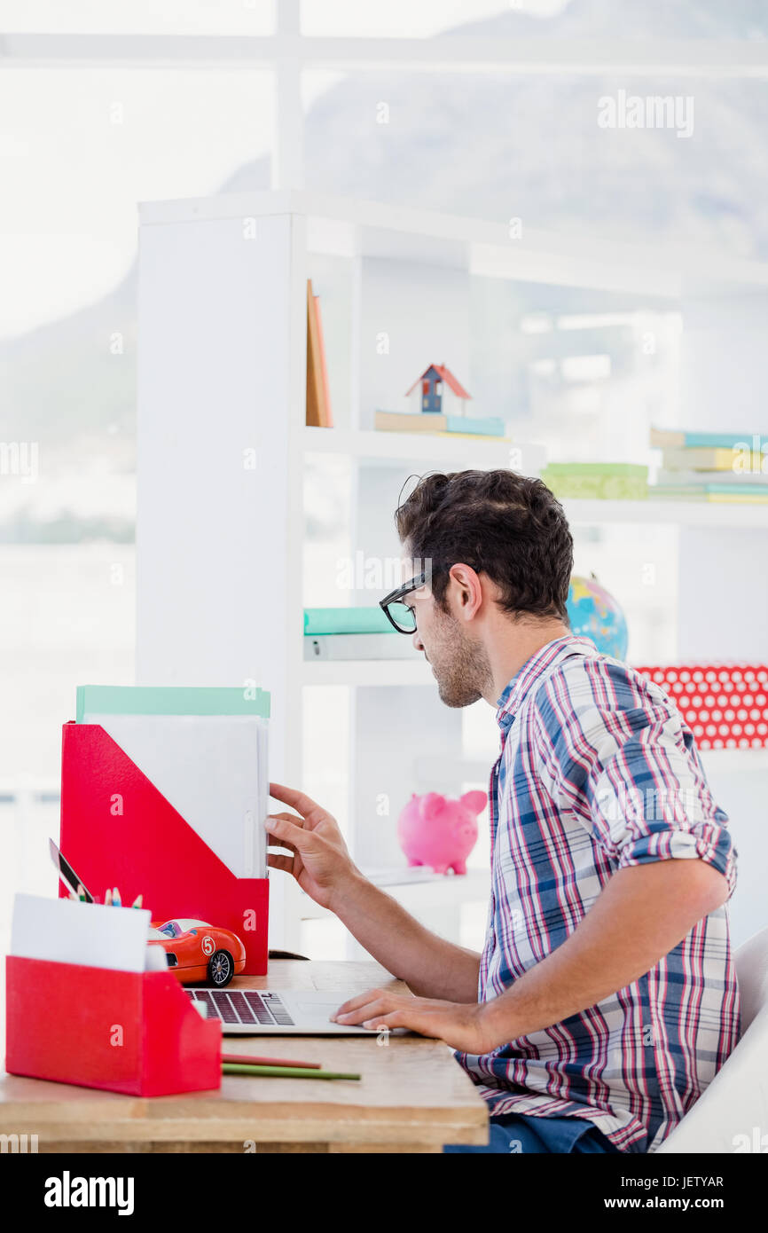 Giovane uomo che lavora alla sua scrivania Foto Stock