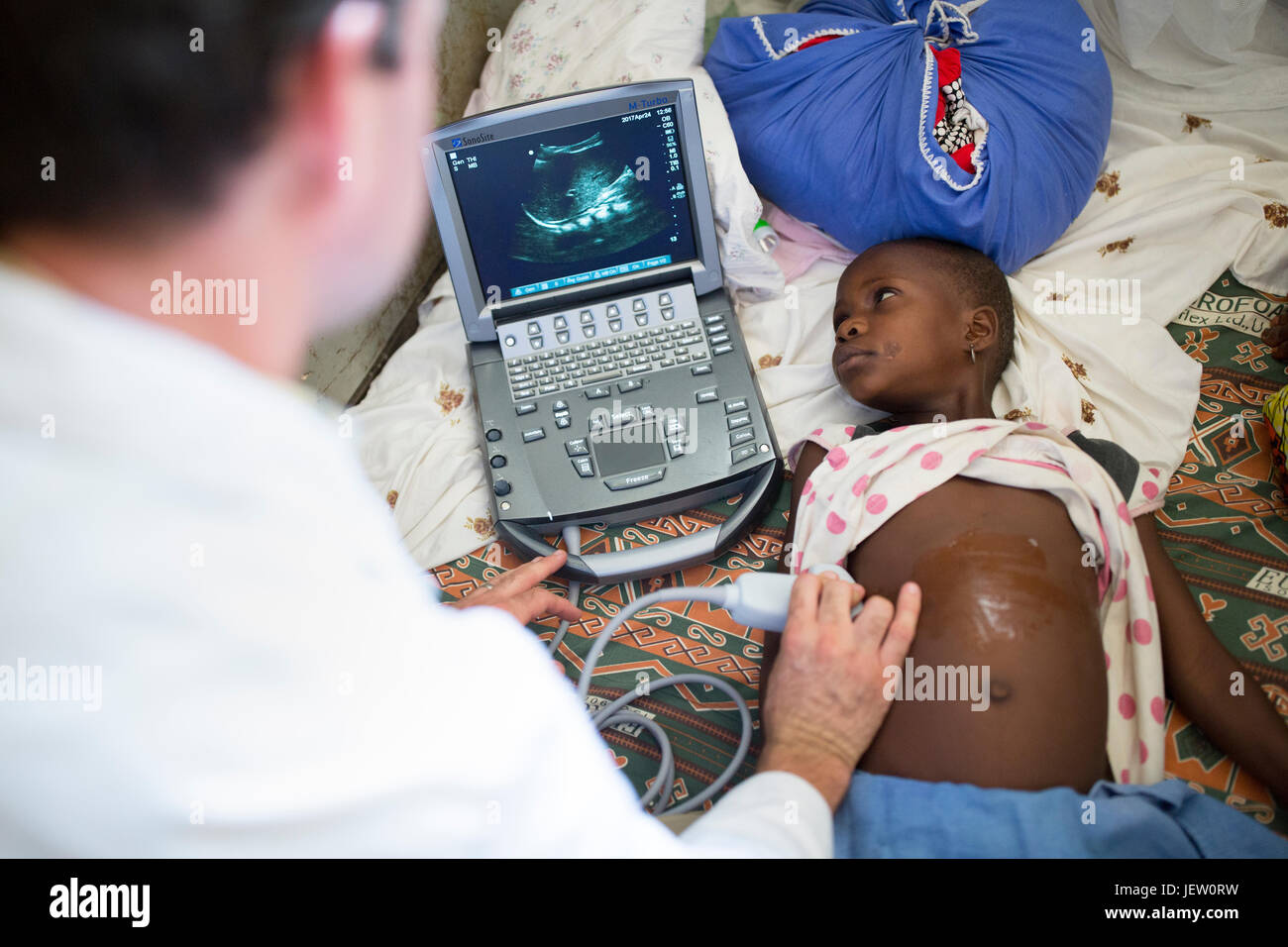 Un expat medico missionario utilizza un portatile kit di ultrasuoni in ospedale di Bundibugyo, Uganda. Foto Stock