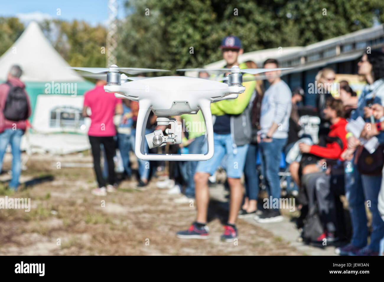 L'uomo controlla il copter. Le persone stanno intorno. Focus sul copter, persone sfocato Foto Stock
